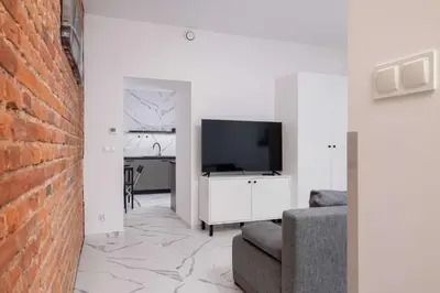 a living room with a flat screen tv and a couch at Cozy Studios in the Old Town of Kraków by Noclegi Renters in Kraków