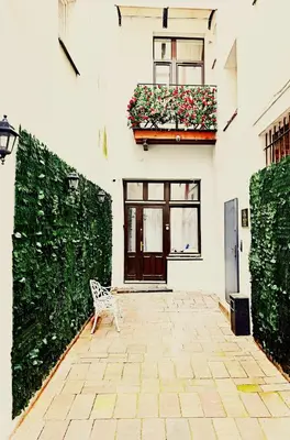 a white building with a bench in a courtyard at The Heritage House Aparthotel Main Square Self Check-In in Kraków