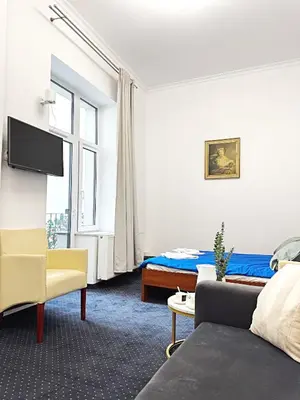 a bedroom with a bed and a couch and a window at The Heritage House Aparthotel Main Square Self Check-In in Kraków