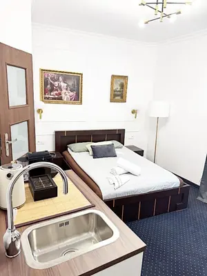 a bathroom with a sink and a bed at The Heritage House Aparthotel Main Square Self Check-In in Kraków
