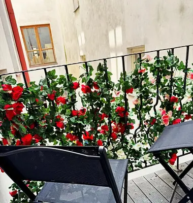 a bunch of red roses growing on a balcony at The Heritage House Aparthotel Main Square Self Check-In in Kraków