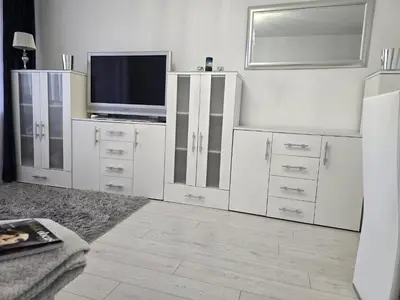 a white living room with a table and a couch at Słoneczne mieszkanie wśród zieleni in Kraków
