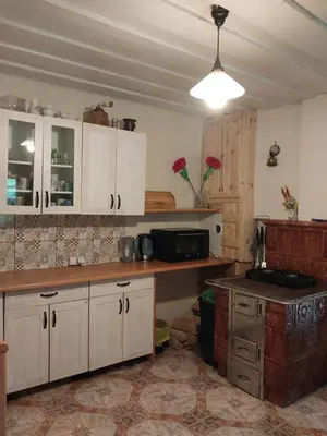 a kitchen with white cabinets and a counter top at Chatka na Lipowych Wzgórzach in Marcówka