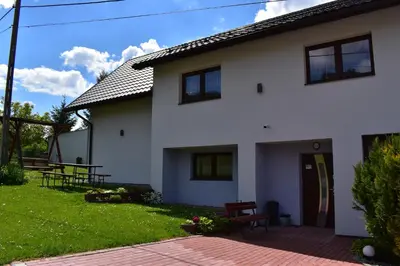 a white house with a patio and a yard at Pokoje pod Śnieżnicą in Kasina Wielka