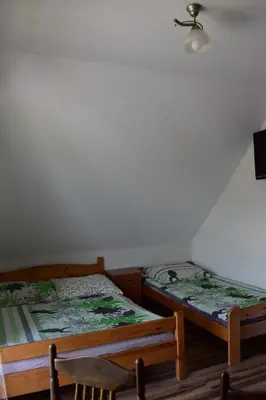 two beds sitting next to each other in a room at Pokoje pod Śnieżnicą in Kasina Wielka