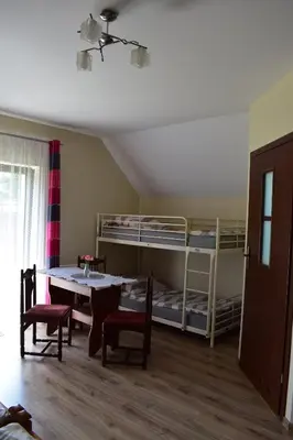 a room with a table and chairs and bunk beds at Pokoje pod Śnieżnicą in Kasina Wielka
