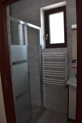 a shower with a glass door in a bathroom at Pokoje pod Śnieżnicą in Kasina Wielka