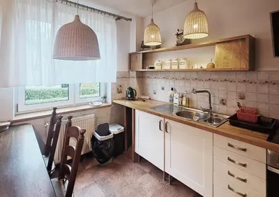 a kitchen with white cabinets and a sink and a window at Mars 5 in Limanowa