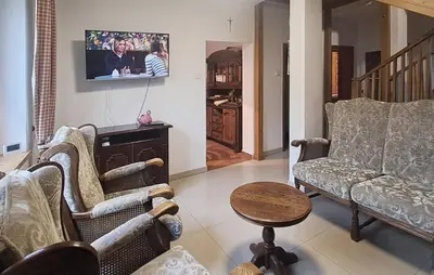 a living room with chairs and a tv on the wall at Mars 5 in Limanowa