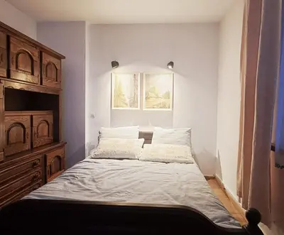 a bedroom with a bed with white sheets and a window at Mars 5 in Limanowa