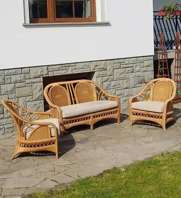 two wicker chairs and a couch in front of a fireplace at Mars 5 in Limanowa