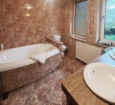 a bathroom with a bath tub and a sink at Mars 5 in Limanowa