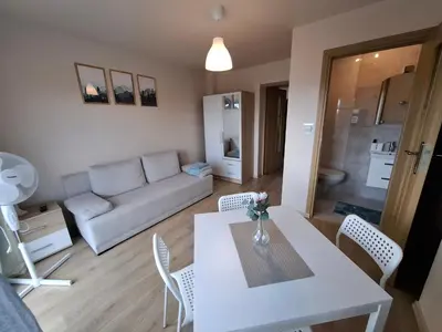 a living room with a white table and chairs at Ważka - pokoje do wynajęcia in Targoszów