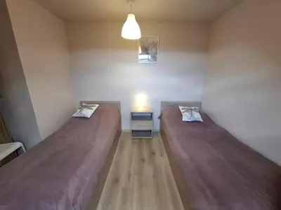 two beds in a small room with a lamp at Ważka - pokoje do wynajęcia in Targoszów