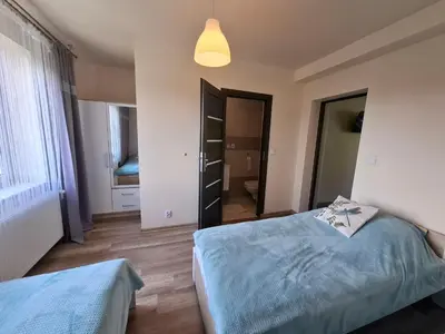 a bedroom with two beds and a light fixture at Ważka - pokoje do wynajęcia in Targoszów