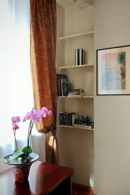 a table with a vase of flowers on it next to a window at Crystal in Kraków