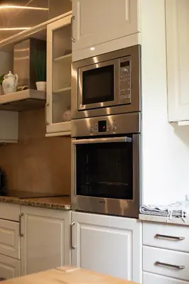 a microwave oven in a kitchen with white cabinets at Crystal in Kraków