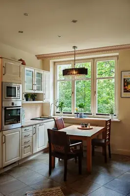 a kitchen with a table and chairs and windows at Crystal in Kraków