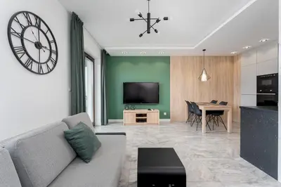 a living room with a couch and a dining room at Przedwiośnie Chic Harmony Apartment by BookingHost in Kraków