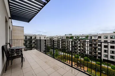 a balcony with a table and a view of buildings at Przedwiośnie Chic Harmony Apartment by BookingHost in Kraków