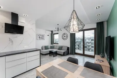 a kitchen and living room with a dining room at Przedwiośnie Chic Harmony Apartment by BookingHost in Kraków