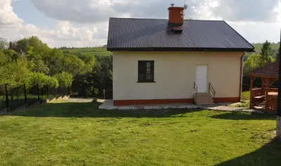 a small white house with a black roof at Grodzisko11 in Skała
