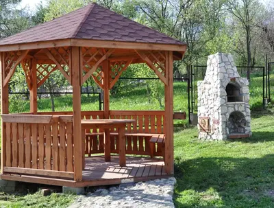 a wooden gazebo with a table and a stone oven at Grodzisko11 in Skała