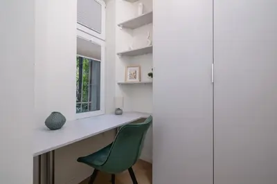 a room with a desk and a green chair at Apartment with balcony - Berka Joselewicza 5 in Kraków