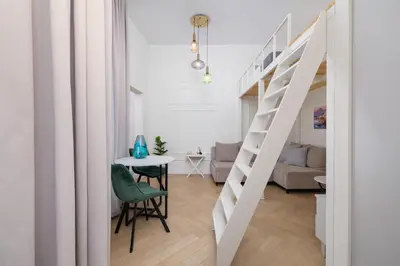a white apartment with a staircase and a table at Apartment with balcony - Berka Joselewicza 5 in Kraków