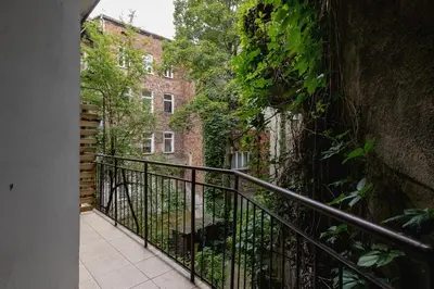 a balcony with a black railing next to a brick building at Apartment with balcony - Berka Joselewicza 5 in Kraków