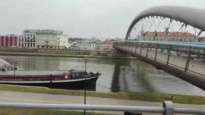 a boat on a river next to a bridge at Old Town Apartment Kazimierz in Kraków