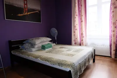 a bedroom with a bed with purple walls and a window at Pokoje Gościnne 