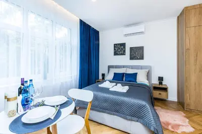 a bedroom with a bed and a table and chairs at Apartament Bonerowska Blue in Kraków
