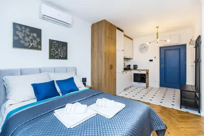 a bedroom with a blue and white bed with two towels at Apartament Bonerowska Blue in Kraków