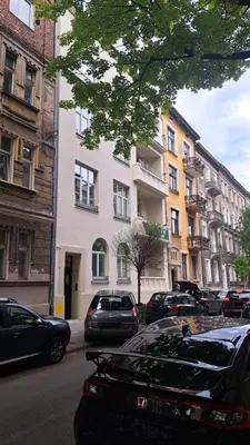 a street with cars parked in front of a building at Apartament Bonerowska Blue in Kraków