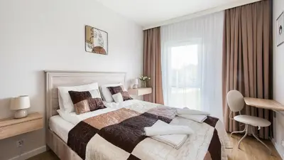 a bedroom with a large bed and a window at Banacha, Sun & Snow in Kraków