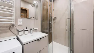 a white bathroom with a sink and a shower at Banacha, Sun & Snow in Kraków