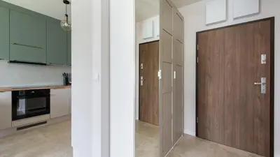 a kitchen with green cabinets and a wooden door at Banacha, Sun & Snow in Kraków