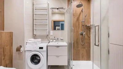 a bathroom with a washing machine and a shower at Banacha, Sun & Snow in Kraków