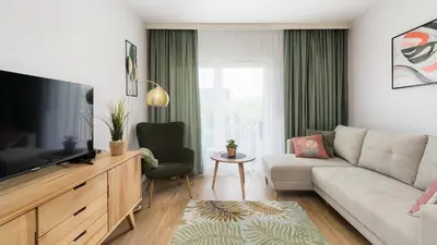 a living room with a couch and a tv at Banacha, Sun & Snow in Kraków