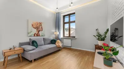 a living room with a couch and a window at Krupnicza Apartment by VSI in Kraków