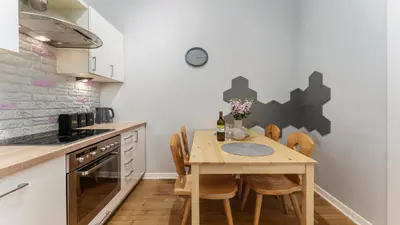 a kitchen with a wooden table and chairs at Krupnicza Apartment by VSI in Kraków