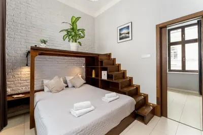 a bedroom with a bed with a stair case at Krupnicza Apartment by VSI in Kraków