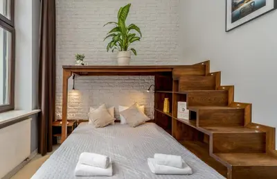 a bedroom with a bed with a wooden headboard at Krupnicza Apartment by VSI in Kraków