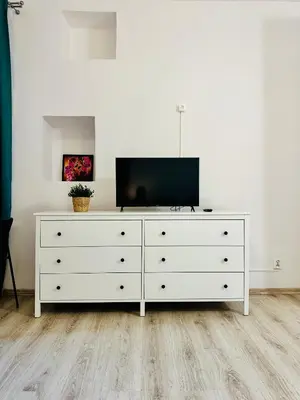 a white dresser with a television on top of it at BD KRAKOW Apart Hotel in Kraków