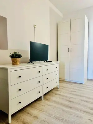 a white dresser with a television on top of it at BD KRAKOW Apart Hotel in Kraków