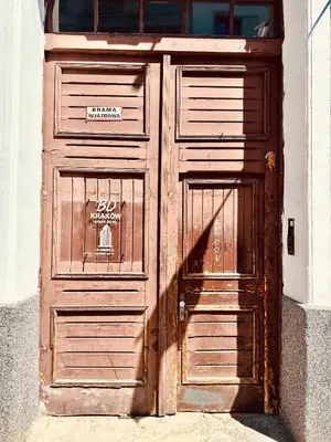 a large wooden door with a sign on it at BD KRAKOW Apart Hotel in Kraków