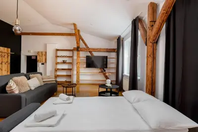 a living room with a bed and a couch at Old Town Wooden Loft Apartment by BookingHost in Kraków