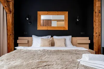 a bedroom with a large bed with a mirror on the wall at Old Town Wooden Loft Apartment by BookingHost in Kraków