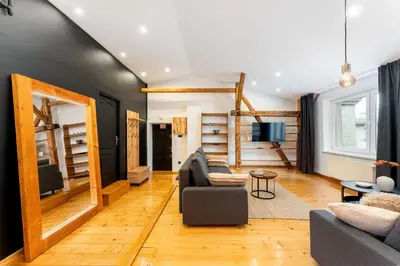 a living room with a couch and a tv at Old Town Wooden Loft Apartment by BookingHost in Kraków